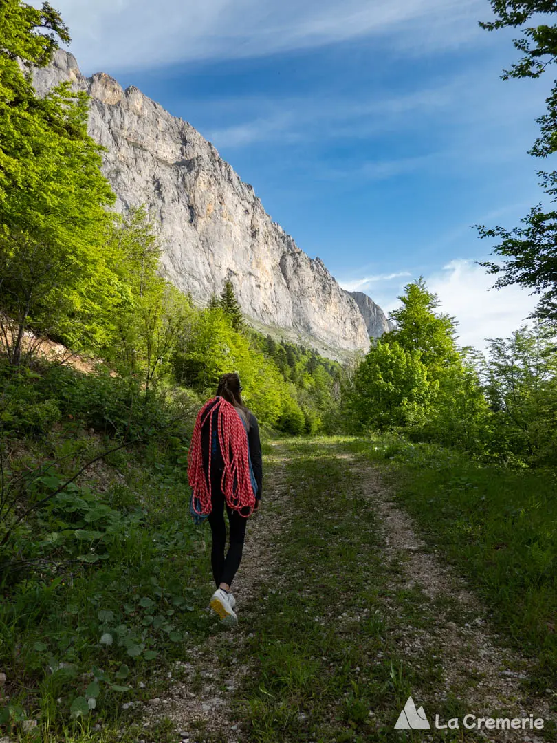 Une grimpeuse marche vers la face Est du Gerbier