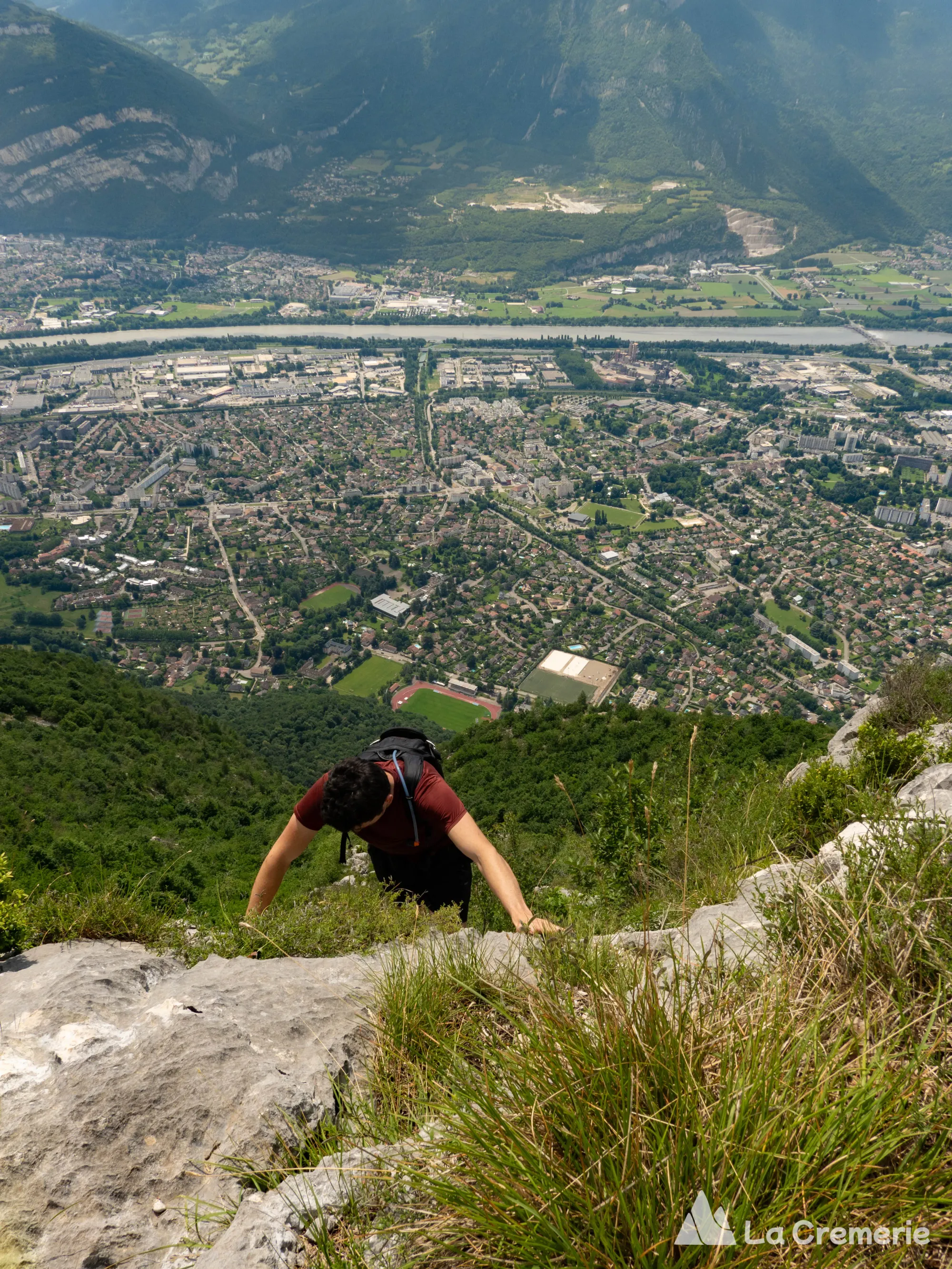 Une personne grimpe sur l'arête des Ecureuils sur le Néron avec la ville de Saint Egrève en arrière plan