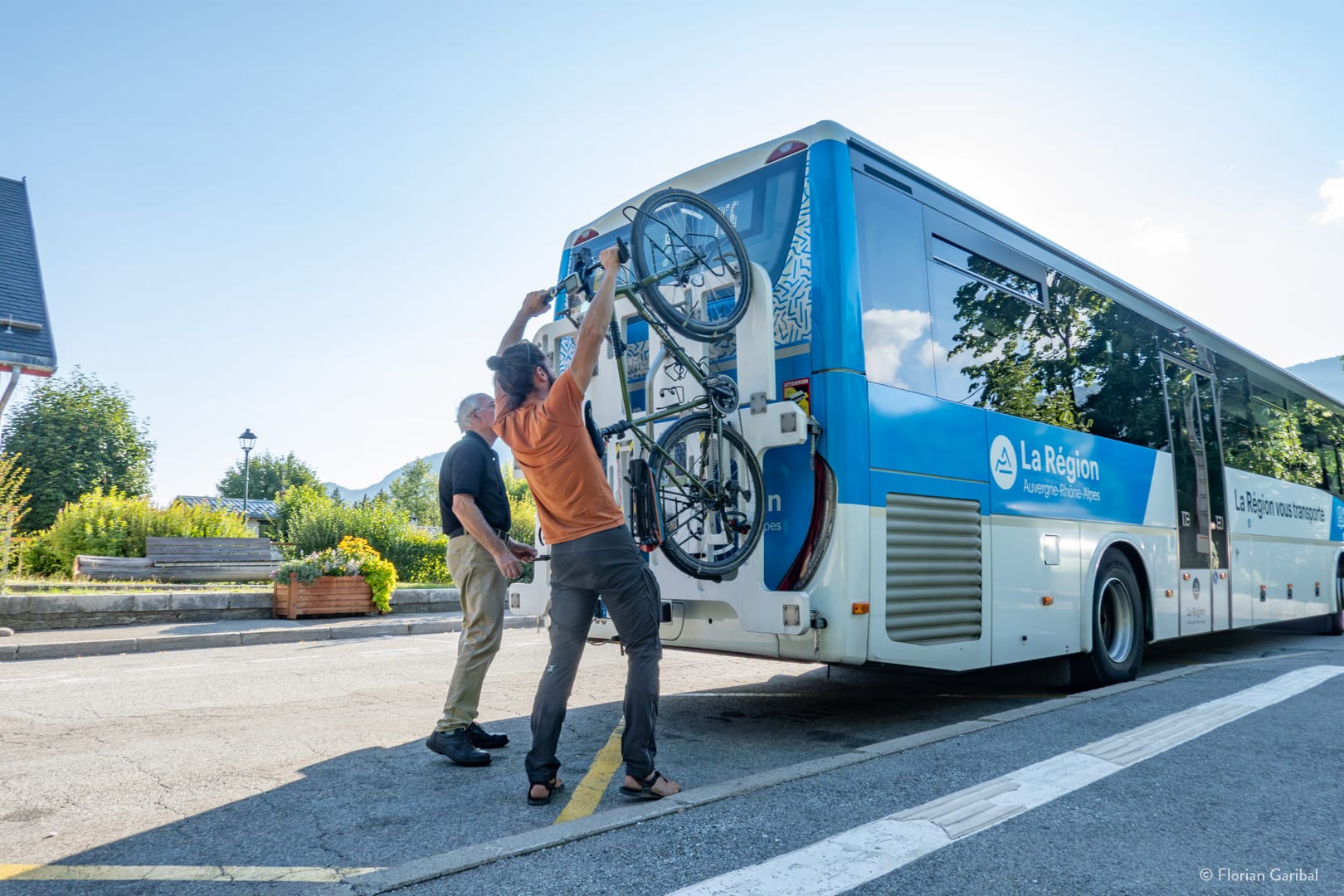 Personne qui monte un vélo sur un bus de la région Auvergne Rhône Alpes